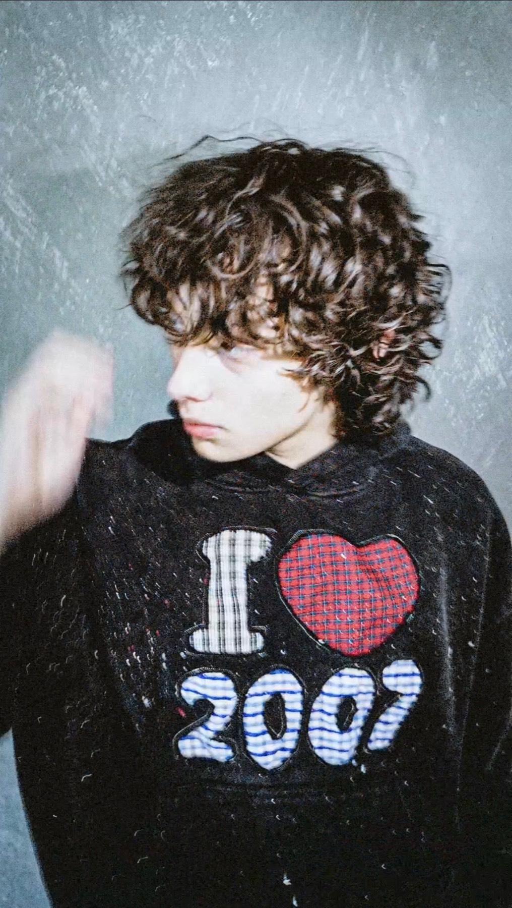 Lookbook photo: the I HEART 2007 hoodie worn against a grey concrete wall